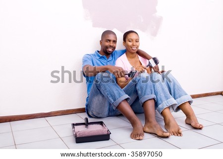happy african american couple painting new house