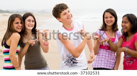teen boy showing off his muscles in front of teen girls