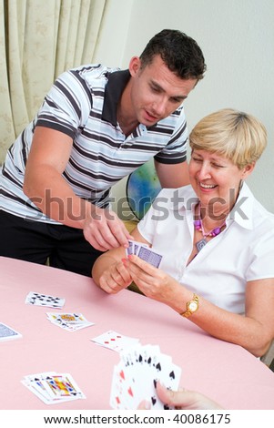 son teaching senior mother how to play cards