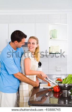 lovely young couple in home kitchen preparing food