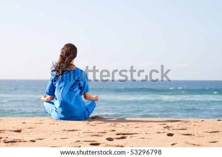rear view of a young nurse meditation on beach