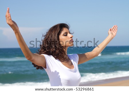 young attractive woman praying on beach