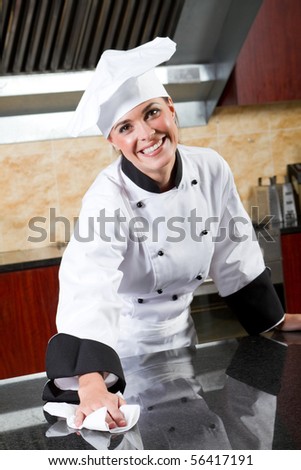 young beautiful female chef cleaning commercial kitchen