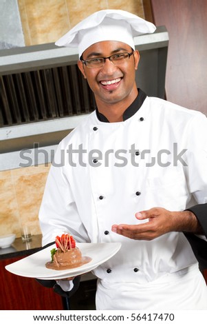 young happy male chef present dessert in commercial kitchen
