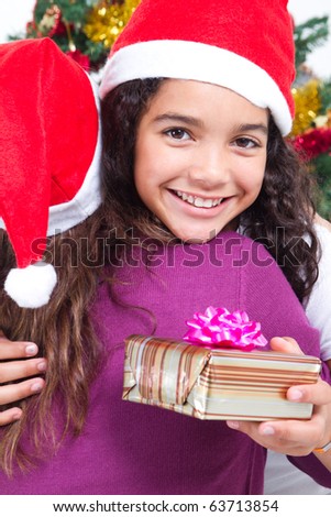 happy girl hugging mother after receiving her Christmas gift