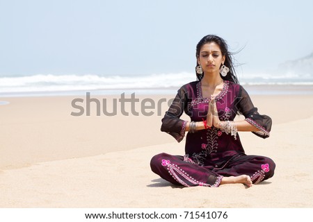 indian woman in traditional clothing on beach meditation