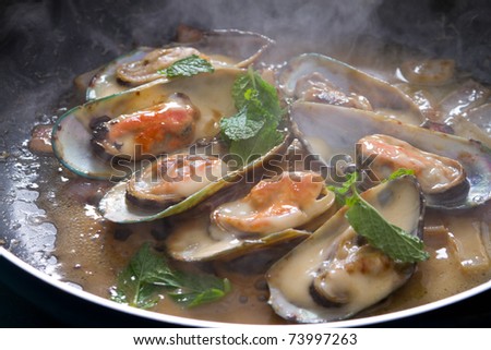 fresh mussels cooking in frying pan