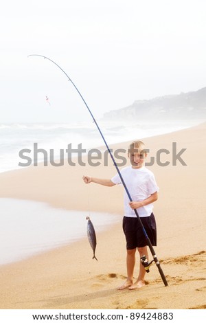 little boy catching a big fish on beach