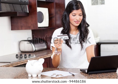 beautiful young indian woman using credit card shopping online