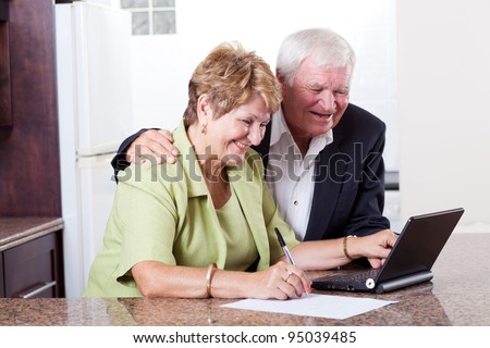 happy senior couple using internet banking checking bank balance