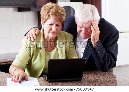 unhappy senior couple worrying about expenses at home