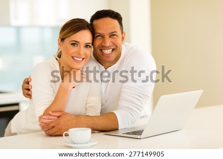 lovely couple with laptop computer at home