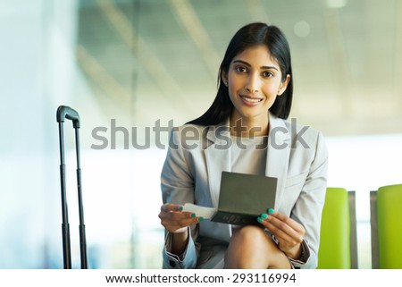 pretty indian woman sitting at airport waiting for her flight