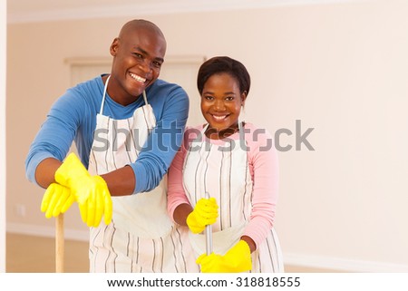 happy african couple cleaning their apartment