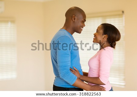 romantic african couple embracing in an empty house