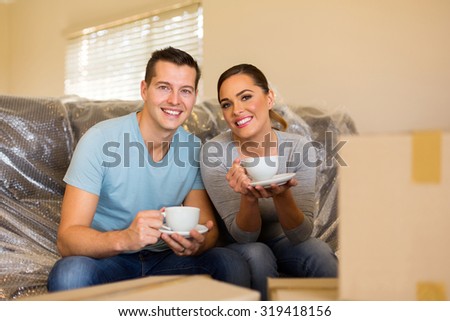 happy young couple having coffee break during moving in new home