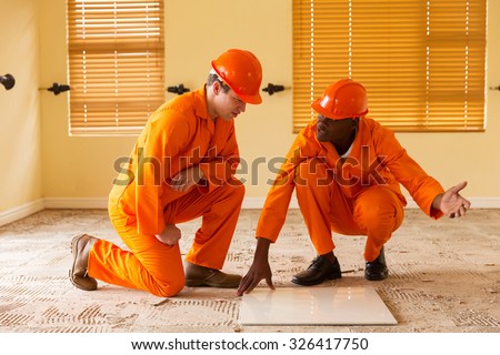 professional construction co-workers discussing floor tiles