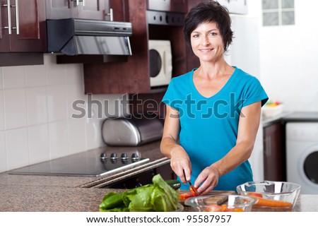 attractive middle aged woman cooking in kitchen