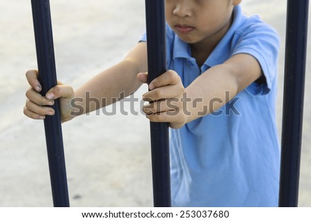 Two hand of a boy holding the black iron bar