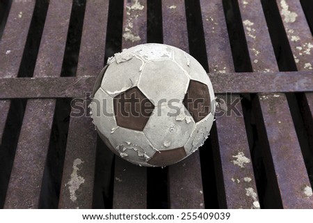 Old football ball on rust iron bar background