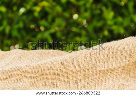 Thin focus old brown ramie sac with green leaf background