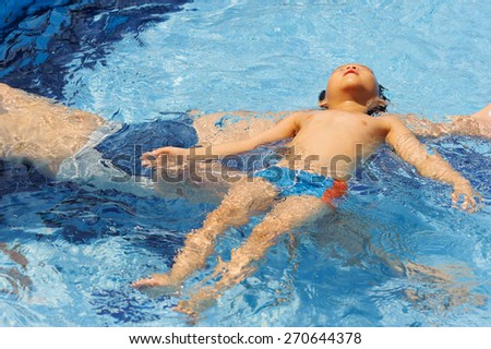 Boy play in the pool with his father