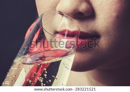 Vintage tone Close up thin focus on red lip Asian young woman drinking champagne