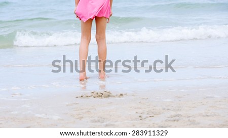 Little asian girl walk on the beach sea side during sunrise