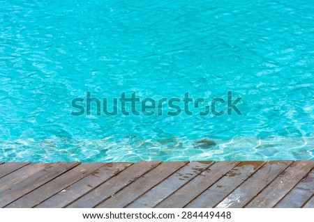 Thin focus on dirty and wet Wood floor beside the green water pool