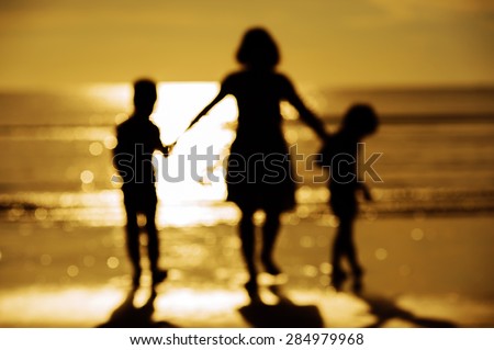 Out focus Silhouette boy mother walk on the beach and sea background