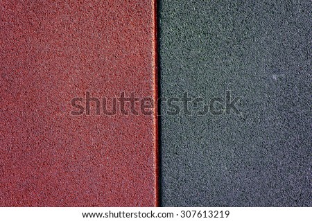 Close up of red and black used and old rubber floor of children play ground
