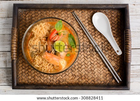 Instant noodle with Tom Yum Goong - Famous and very delicious food that hot and spicy soup with shrimp that could easily found in most of resturant in Thailand, serve in glass bowl. Thai Cuisine