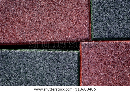 Close up of red and black used and old rubber floor of children play ground