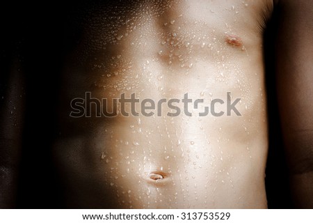 Dark tone color. Close up on skin body muscle and sweat drop on young strong Asian boy body after heavy exercise