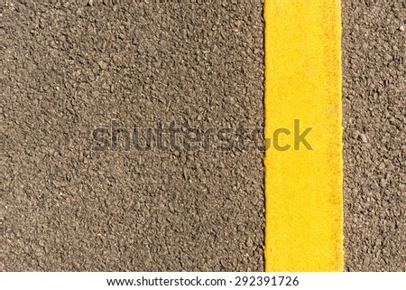 close up of asphalt road with yellow stripes