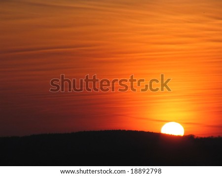 Orange sun behind the hill