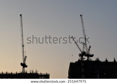 Silhouette Construction building site with cranes in the sunset evening time in Bangkok, Thailand