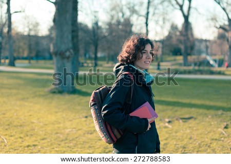 Young student holding books and walking around campus