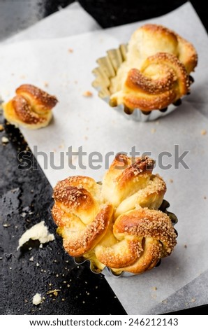 Freshly baked rolls on parchment paper and black iron background