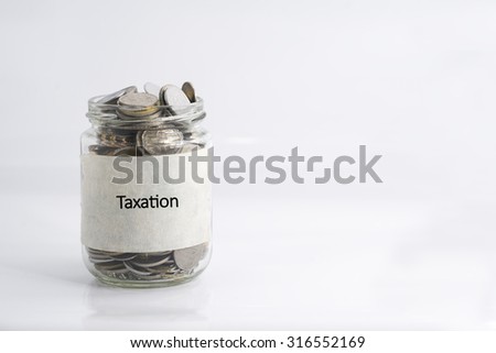 Isolated coins in jar with taxation label; financial concept