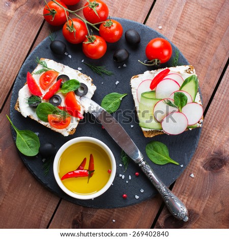 Wholemeal sandwiches with fresh vegetables on wooden background. Square image, selective focus