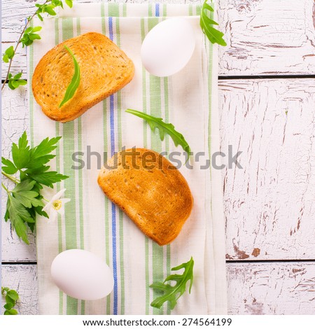 Health breakfast concept: crunchy toasts with boiled eggs on white wooden table. Top view. Square image