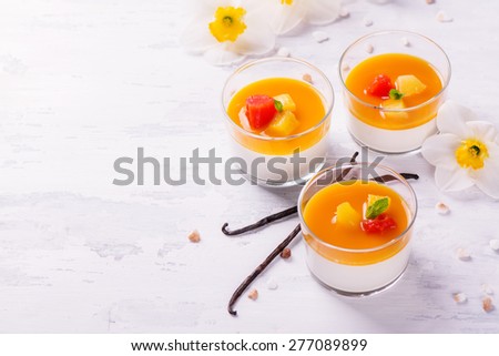 Dessert panna cotta with fresh berries and vanilla pods on wooden background, selective focus. Space for text
