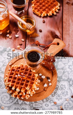 Fresh thick belgium waffles with honey and coffee on a wooden background. Selective focus