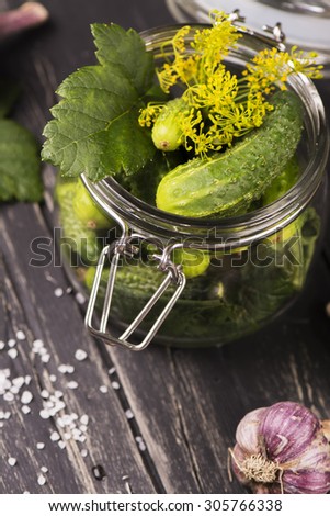 Rich harvest of fresh organic cucumbers ready for pickling in a glass jar. Vintage style. Selective focus