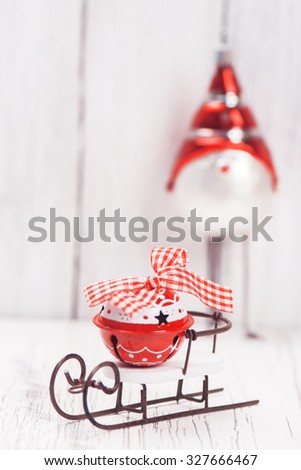 Xmas or new year composition with sledge, little bell and funny bird on white wooden background. Xmas card. Space for text. Selective focus