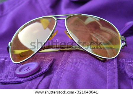Sunglasses are on the purple jacket