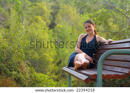 Smiling Ballerina sitting on a park bench.