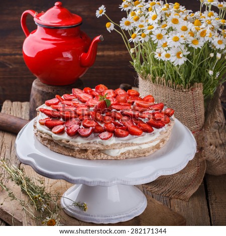Cake meringue cakes with strawberries .Bouquet of daisies in a vase.selective focus