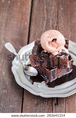 Chocolate brownie with raspberries in a chocolate glaze, served with a scoop of chocolate ice cream.selective focus